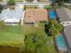 Aerial view showcasing houses with well-kept lawns, inground pools, and a pond in the backyard at 3330 Foxridge Cir, Tampa, FL 33618
