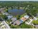 An aerial view showcasing homes situated around a serene lake, surrounded by mature trees at 3330 Foxridge Cir, Tampa, FL 33618