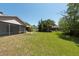 A spacious backyard with a screened porch and lush green lawn, ideal for outdoor activities at 3330 Foxridge Cir, Tampa, FL 33618