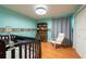 Bright Bedroom featuring a dark wood crib, matching desk and chair, and ample natural light at 3330 Foxridge Cir, Tampa, FL 33618