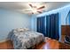 Bedroom features wood floors, window with dark curtains, and stylish bedding at 3330 Foxridge Cir, Tampa, FL 33618
