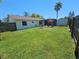 Large backyard with green grass, a fire pit, a shed, and a screened patio for entertainment at 4505 Alligator Dr, New Port Richey, FL 34653