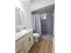 Bathroom with tiled shower, grab bar, and vanity with white marble countertops at 4505 Alligator Dr, New Port Richey, FL 34653
