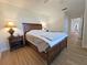 A bedroom with wood flooring, a wooden bed frame, and light-colored walls at 4505 Alligator Dr, New Port Richey, FL 34653