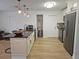 An open kitchen features white cabinets, stainless steel appliances, a granite countertop island, and wood floors at 4505 Alligator Dr, New Port Richey, FL 34653
