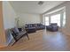 Bright living room with a bay window, wood-look floors, and modern furnishings at 4505 Alligator Dr, New Port Richey, FL 34653