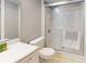 Bathroom with white walk-in shower, sink, and toilet with white tile flooring at 5005 Puritan Rd, Tampa, FL 33617
