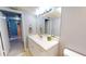 Bathroom with single sink vanity, large mirror, and linen closet for storage at 5005 Puritan Rd, Tampa, FL 33617