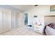 Bedroom with white closets, a bed, and a nightstand with tile floors at 5005 Puritan Rd, Tampa, FL 33617