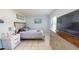 Bright bedroom with a queen bed, tiled floor, and chest of drawers under the TV at 5005 Puritan Rd, Tampa, FL 33617