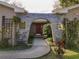 Unique home entrance with stone archway, lattice, and lush foliage leading to the front door at 5005 Puritan Rd, Tampa, FL 33617