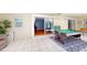 A spacious game room features a pool table, seating, tile floors, and sliding door access to other rooms at 5005 Puritan Rd, Tampa, FL 33617