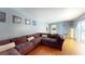 Bright living room with wood floors, large sectional sofa, and sliding glass doors to outdoor area at 5005 Puritan Rd, Tampa, FL 33617
