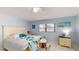 A bright main bedroom showcases comfortable seating, white tile floor, and an artistic beach theme at 5005 Puritan Rd, Tampa, FL 33617