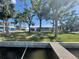Backyard featuring mature trees, lush green lawn, and water access at 5425 Bluepoint Dr, Port Richey, FL 34668
