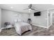 A bedroom with hardwood floors, a ceiling fan, a television, and light gray walls at 5425 Bluepoint Dr, Port Richey, FL 34668