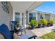 Charming front porch featuring cozy chairs, a small table, and lush potted plants enhancing the home's welcoming appeal at 5425 Bluepoint Dr, Port Richey, FL 34668