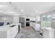 Open kitchen features stainless steel appliances, gray backsplash, sleek white cabinets, and wood-look tile floors at 5425 Bluepoint Dr, Port Richey, FL 34668