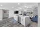 An open-concept kitchen with a white central island with stainless appliances and modern countertops at 5425 Bluepoint Dr, Port Richey, FL 34668