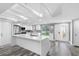Modern kitchen featuring white cabinets, stainless steel appliances, a large island, and stylish pendant lighting at 5425 Bluepoint Dr, Port Richey, FL 34668