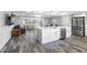 Open concept kitchen and living area with large island, stainless steel appliances, and wood look tile floors at 5425 Bluepoint Dr, Port Richey, FL 34668