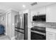 Contemporary kitchen featuring stainless steel appliances, sleek white cabinets, and modern backsplash at 5425 Bluepoint Dr, Port Richey, FL 34668