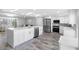 Spacious open kitchen features a large island, stainless steel appliances, and stylish wood-look tile flooring at 5425 Bluepoint Dr, Port Richey, FL 34668