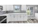 Bright kitchen features white cabinets, countertops, stainless oven, and tile backsplash with a bright window at 5425 Bluepoint Dr, Port Richey, FL 34668