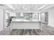 Bright open kitchen featuring a large island, stainless appliances, stylish pendant lights, and wood look tile flooring at 5425 Bluepoint Dr, Port Richey, FL 34668