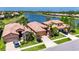 Aerial view of a tile roofed home near a lake with manicured landscaping and a two-car garage at 5728 Sunset Falls Dr, Apollo Beach, FL 33572