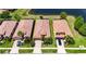 Aerial view of a neighborhood with terracotta roofs surrounding a pond and lush landscaping at 5728 Sunset Falls Dr, Apollo Beach, FL 33572
