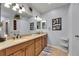Bathroom featuring a long wood vanity with double sinks and tile flooring, under bright lighting at 5728 Sunset Falls Dr, Apollo Beach, FL 33572