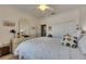 Bright bedroom with white-washed walls, closet with doors, white bedding, and a stylish ceiling fan at 5728 Sunset Falls Dr, Apollo Beach, FL 33572