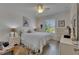 Bright bedroom with white-washed walls, closet with doors, white bedding, and a stylish ceiling fan at 5728 Sunset Falls Dr, Apollo Beach, FL 33572