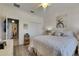 Bright bedroom with white-washed walls, closet with doors, white bedding, and a stylish ceiling fan at 5728 Sunset Falls Dr, Apollo Beach, FL 33572