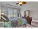 Comfortable bedroom with a large window, tray ceiling and wood-look floors at 5728 Sunset Falls Dr, Apollo Beach, FL 33572