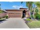 Charming single-story home featuring a tile roof, two-car garage, and lush landscaping at 5728 Sunset Falls Dr, Apollo Beach, FL 33572