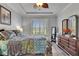 The bedroom is a cozy retreat, featuring a large window with shutters, a beautiful dresser, and stylish gray wood-look floors at 5728 Sunset Falls Dr, Apollo Beach, FL 33572