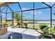 A screened-in patio with tiled floors offers serene lake views and outdoor living at 5728 Sunset Falls Dr, Apollo Beach, FL 33572