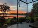 Relaxing screened patio offers a stunning sunset view over the lake, enhanced by beautiful flowers and landscaping at 5728 Sunset Falls Dr, Apollo Beach, FL 33572