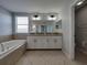 Bathroom featuring double sinks, a vanity, a tub, and a separate shower at 6222 Trent Creek Dr, Sun City Center, FL 33573