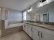 Elegant bathroom boasts double sinks with granite countertops and a large vanity mirror at 6222 Trent Creek Dr, Sun City Center, FL 33573