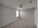 Empty bedroom featuring soft gray walls, plush gray carpeting, and natural light at 6222 Trent Creek Dr, Sun City Center, FL 33573