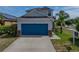 Attractive home featuring a blue garage door, stone accents, landscaping and well maintained lawn at 6222 Trent Creek Dr, Sun City Center, FL 33573