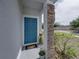 Charming home entrance with a striking blue front door and decorative stone pillar at 6222 Trent Creek Dr, Sun City Center, FL 33573