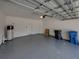 An empty, spacious two-car garage with a light grey painted floor at 6222 Trent Creek Dr, Sun City Center, FL 33573