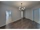 Spacious living room with wood floors and modern light fixture, seamlessly flowing into the kitchen at 6222 Trent Creek Dr, Sun City Center, FL 33573