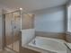 Bathroom featuring a glass-enclosed shower, soaking tub, and tile accents at 6222 Trent Creek Dr, Sun City Center, FL 33573