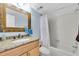 Bathroom featuring a granite vanity, decorative mirror, and shower over tub combination at 6279 Sun Blvd # 103, St Petersburg, FL 33715