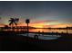 The beautiful waterfront pool at sunset shows palm trees, lounge chairs, and the bridge at 6279 Sun Blvd # 103, St Petersburg, FL 33715